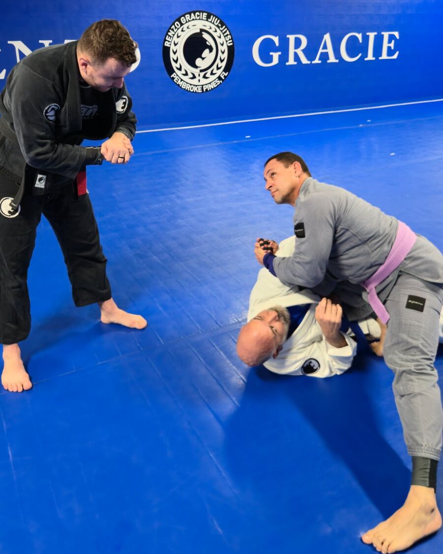 A Renzo Gracie Pembroke Pines coach giving hands-on help to two students during class